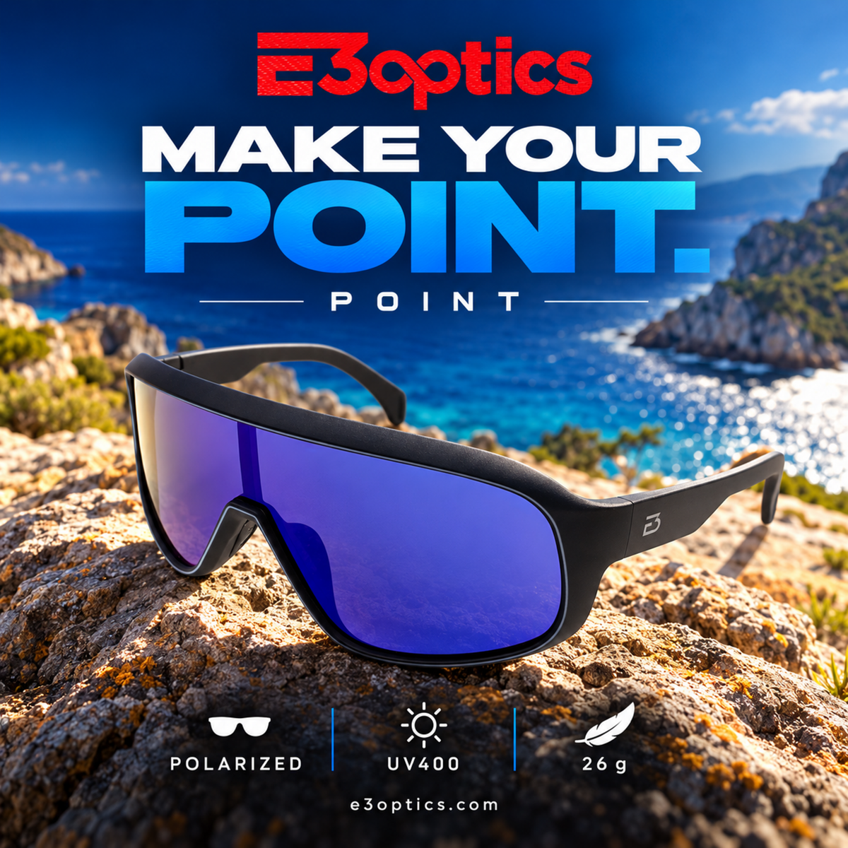 E3optics Point sunglasses with a black frame and blue-purple mirrored lenses, shown resting on a rocky coastal cliff with the ocean in the background. Large promotional text at the top reads 'E3optics MAKE YOUR POINT.
