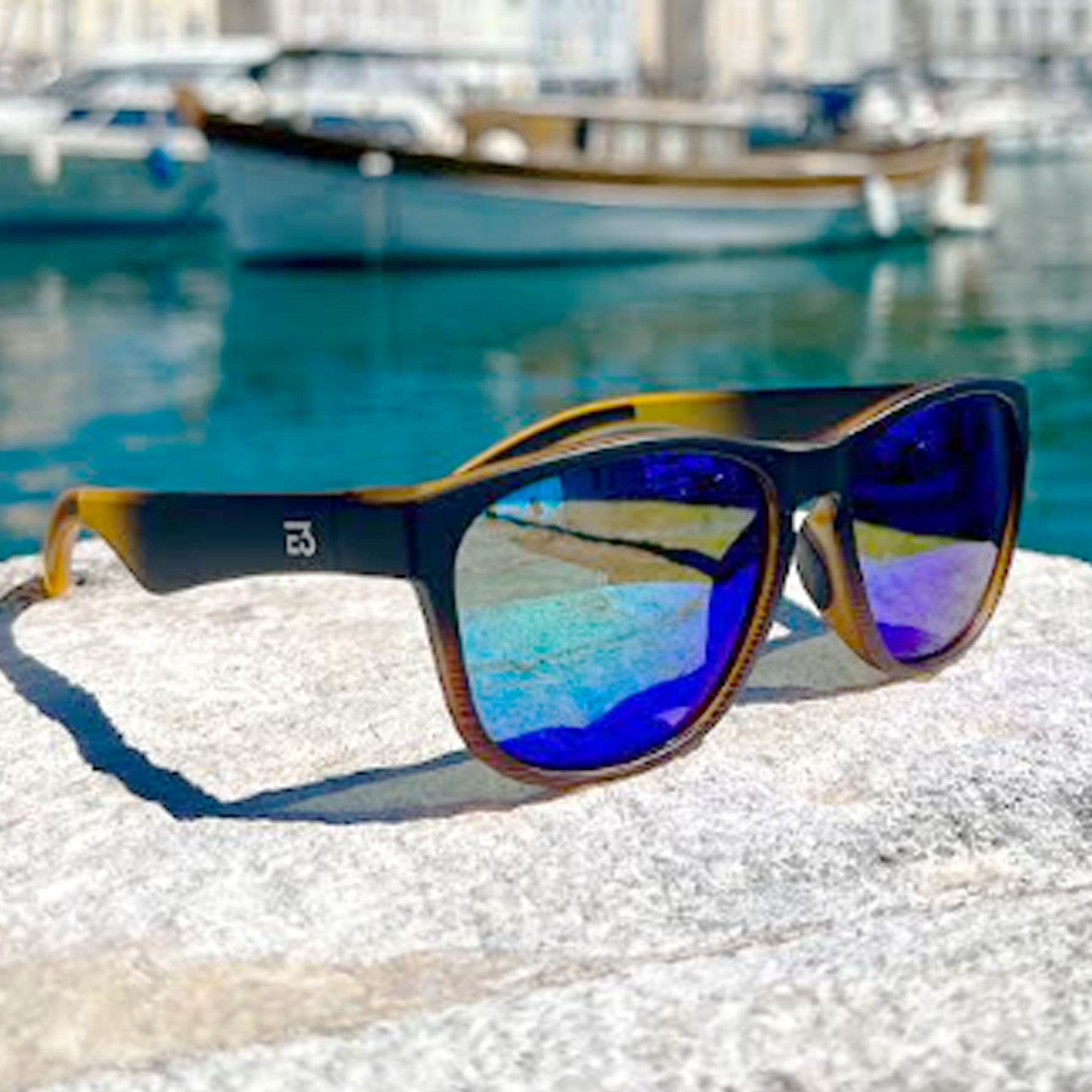 E3 Optics E17 floating polarized sunglasses on dock – perfect for fishing, boating, and water sports.