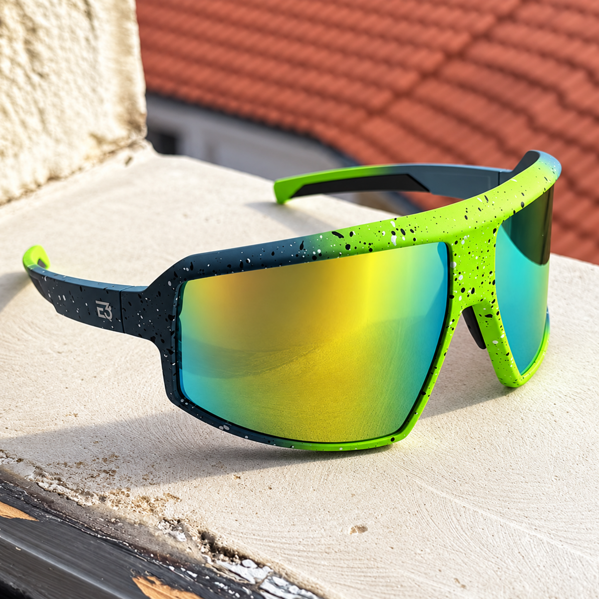 Sport sunglasses with a bright neon green and black speckled frame and mirrored yellow-to-blue lenses, resting on a concrete ledge outdoors.